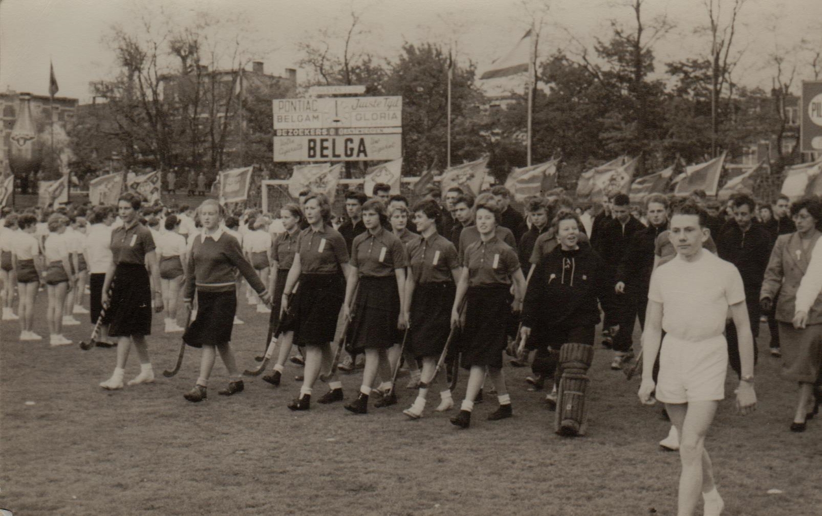 1955: aankomst van de Rotterdamse ploeg in het stadion in Antwerpen, achter de hockeyploeg het in trainingspak gestoken atletiekteam